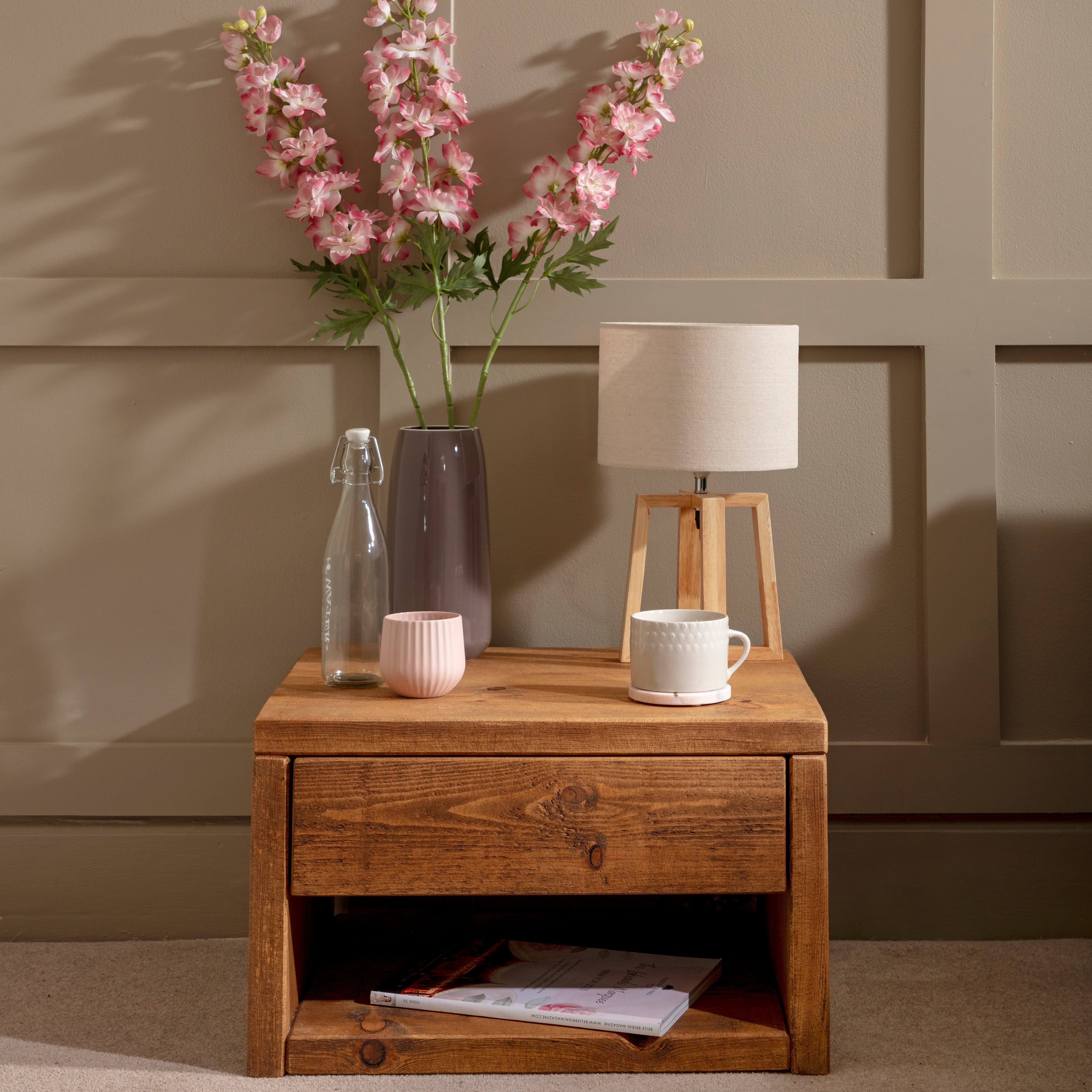 Solid wood Pandon bedside table, styled with a lamp, flowers and magazines